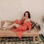 A woman in an orange dress reclines on a beige sofa with pillows near a green plant, with a patterned rug and cream textured wall—an inviting setting perfect for OEM or ODM inspiration. Featured: blog-5.