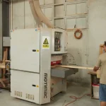 Two people wearing masks operate the Wooden furniture 4 machine, feeding a long wooden plank through it in an OEM/ODM workshop.