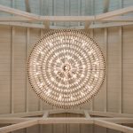 The abcdhe-2 is a circular chandelier with multiple lights, ideal for OEM or ODM projects, designed to hang from wooden ceilings with exposed beams and viewed from directly below.