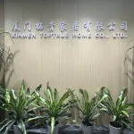 Lobby wall showcasing the company profile, with "XIAMEN TOPTRUE HOME CO., LTD." in Chinese and English, complemented by several green potted plants in front.