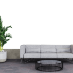 A modern gray sofa with a wire-frame coffee table sits next to a large potted plant on a tiled floor against a black background.