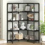 The 02.01.C_结果 black metal corner bookshelf features five shelves and is available for ODM and OEM orders, displaying books, decor, a gramophone, a bust, baskets, boxes, and photos in a bright room beside stairs.