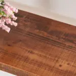 A close-up of the 02.01.C_结果 wooden tabletop with a rustic finish, featuring a bouquet of pink flowers in the upper left corner—ideal for highlighting your ODM or OEM product designs.