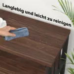 A hand wipes water droplets off a wooden table with a cloth. German text above reads "Langlebig und leicht zu reinigen" (Durable and easy to clean). 04.01.C_结果: Ideal for ODM/OEM projects prioritizing quality and practicality.