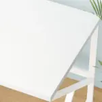 The 04.01.C_结果 is a white rectangular table with a minimalist design, ideal for ODM or OEM projects. It's shown on a light wooden floor with green plant leaves visible at the edge of the scene.
