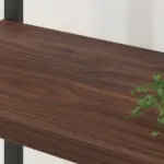 A close-up of the 04.01.C_结果 wooden shelf with a dark wood grain finish; a green leafy plant is partially visible on the right, highlighting its elegant design for OEM and ODM customization.