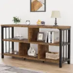 The 05.01.C_结果 open bookshelf, made of wood and metal, is ideal for ODM/OEM projects and displays books, decor, a lamp, a clock, fruit, with a plant on top; a framed abstract artwork hangs above.