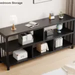 The 4_结果 is a black, three-tier open shelf suited for ODM and OEM services, ideal for holding books, boxes, a globe, lamp, or decor items and designed to complement bedroom walls with light wood flooring.