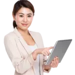 A woman in a light-colored Toptrue blazer is holding and using a tablet, looking at the camera with a neutral expression.